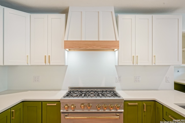 kitchen with white cabinetry, custom range hood, green cabinetry, and high end stove