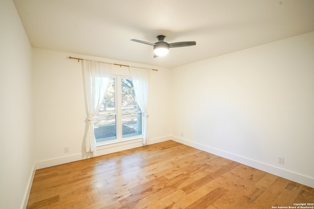 spare room with ceiling fan and light wood-type flooring