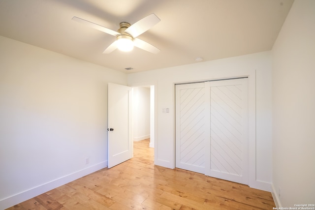 unfurnished bedroom with a closet, light hardwood / wood-style floors, and ceiling fan