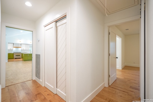 hall featuring light hardwood / wood-style floors and vaulted ceiling