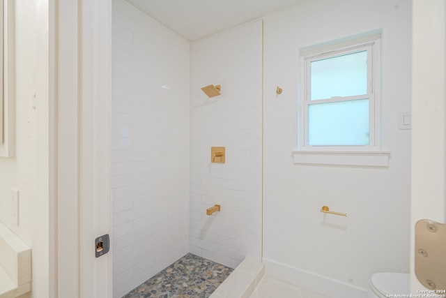 bathroom featuring toilet and tiled shower