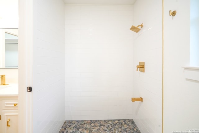 bathroom featuring a tile shower and vanity