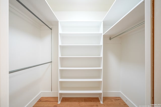 spacious closet with hardwood / wood-style floors