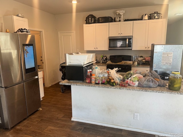 kitchen featuring dark wood-type flooring, light stone counters, stainless steel appliances, and white cabinets