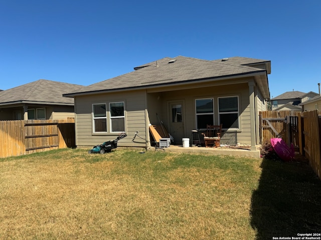 rear view of house featuring a lawn