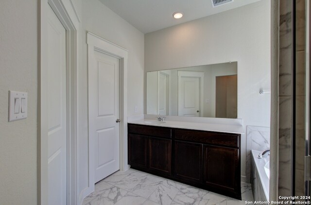 bathroom with vanity and a tub