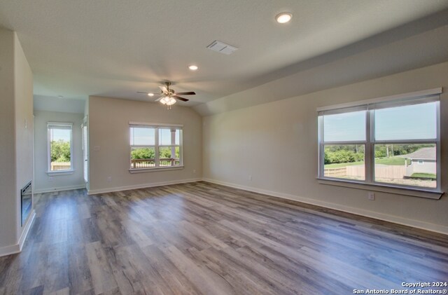 spare room featuring ceiling fan, wood-type flooring, and vaulted ceiling