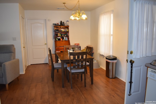 dining area with an inviting chandelier and dark hardwood / wood-style flooring