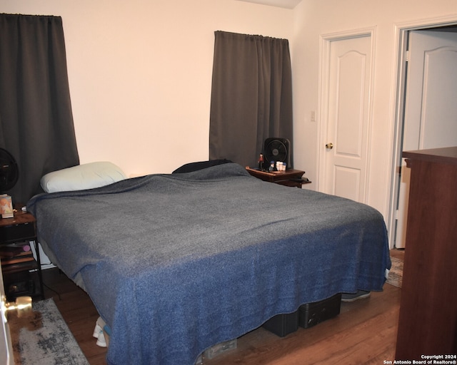 bedroom with dark hardwood / wood-style flooring