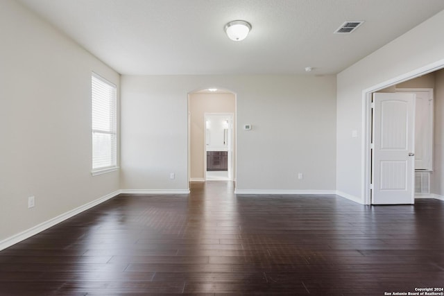 unfurnished room featuring a textured ceiling and dark hardwood / wood-style floors