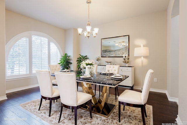 dining area with dark hardwood / wood-style floors and an inviting chandelier