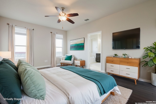 bedroom with connected bathroom, ceiling fan, multiple windows, and dark hardwood / wood-style floors