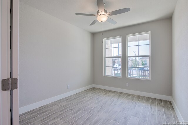 spare room with light wood-type flooring and ceiling fan