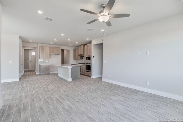 kitchen featuring a kitchen island with sink, light brown cabinets, sink, ceiling fan, and light hardwood / wood-style flooring