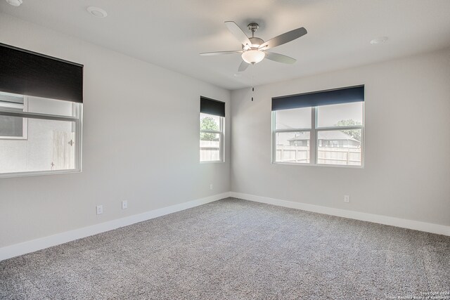 unfurnished room with ceiling fan and carpet floors