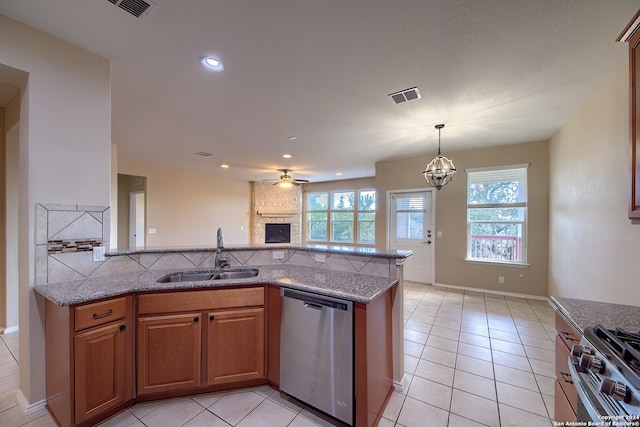 kitchen with appliances with stainless steel finishes, sink, ceiling fan with notable chandelier, and a wealth of natural light