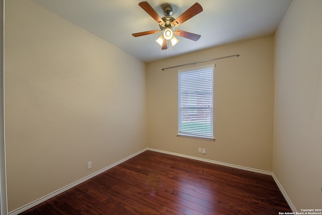 spare room featuring dark wood-type flooring and ceiling fan