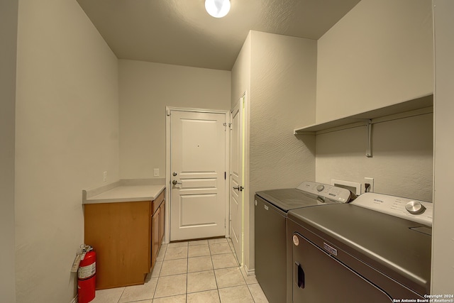 washroom featuring light tile patterned flooring, separate washer and dryer, and cabinets