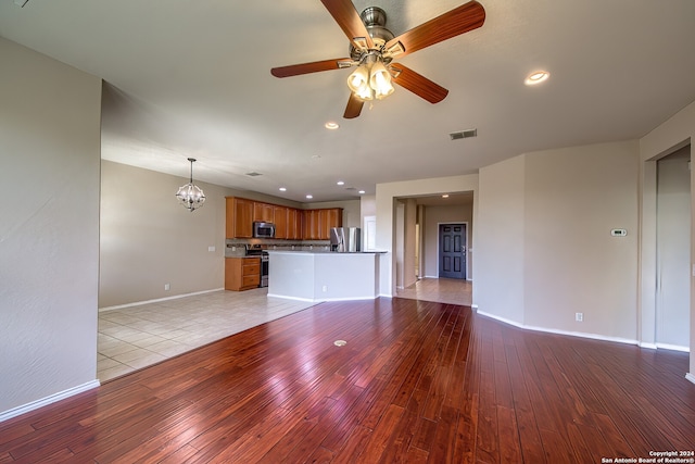 unfurnished living room with light hardwood / wood-style floors and ceiling fan with notable chandelier