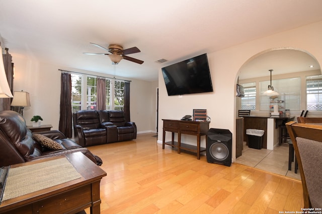 living room with ceiling fan, light wood-type flooring, and plenty of natural light