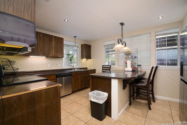 kitchen with a breakfast bar, light tile patterned flooring, dishwasher, and decorative light fixtures