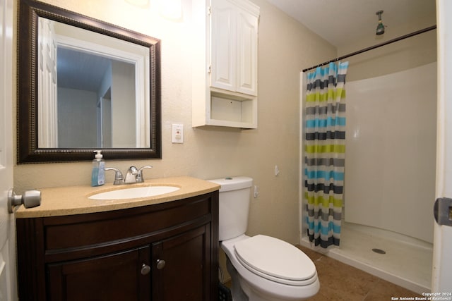 bathroom with vanity, tile patterned floors, toilet, and walk in shower