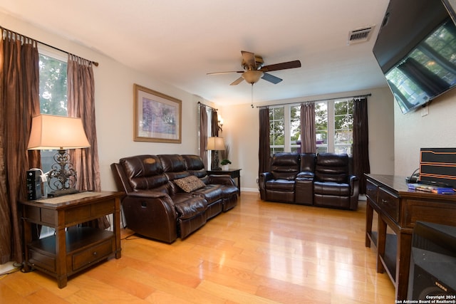 living room with light wood-type flooring, a healthy amount of sunlight, and ceiling fan