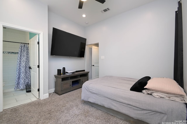 bedroom with ensuite bath, light colored carpet, and ceiling fan