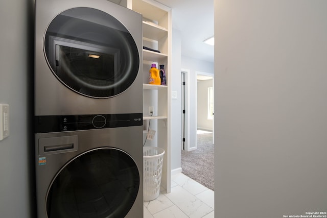 washroom featuring stacked washer and dryer and light colored carpet