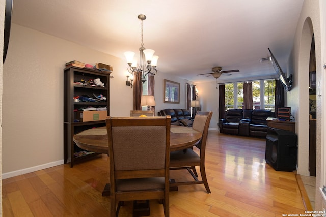 dining area featuring hardwood / wood-style flooring and ceiling fan with notable chandelier