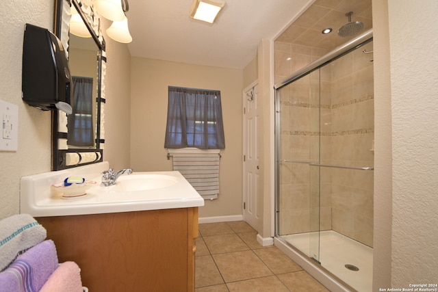 bathroom featuring vanity, tile patterned floors, and a shower with door