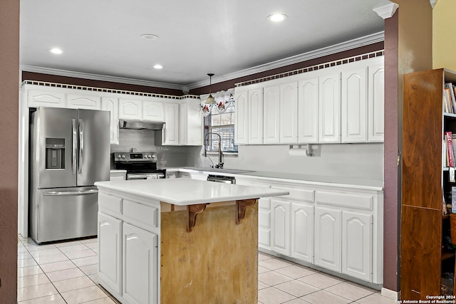 kitchen with white cabinets, a kitchen island, appliances with stainless steel finishes, crown molding, and decorative light fixtures