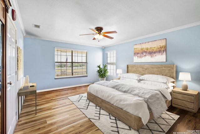 bedroom with a closet, ornamental molding, hardwood / wood-style flooring, and ceiling fan