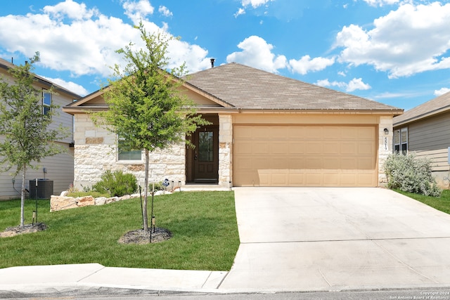 view of front of property with a front yard, a garage, and cooling unit