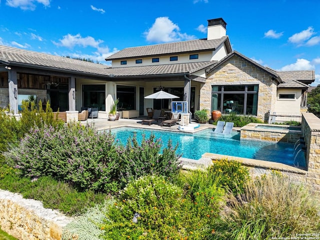 back of property featuring pool water feature, a patio area, and a pool with hot tub