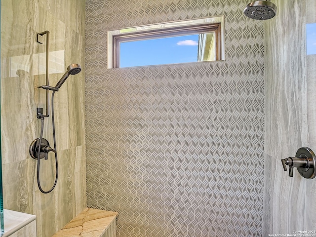 bathroom featuring a tile shower and a healthy amount of sunlight