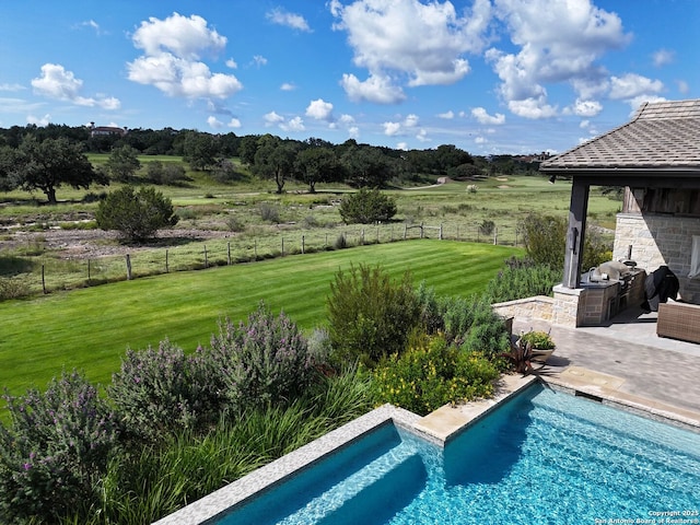 view of pool featuring a rural view, a yard, and area for grilling