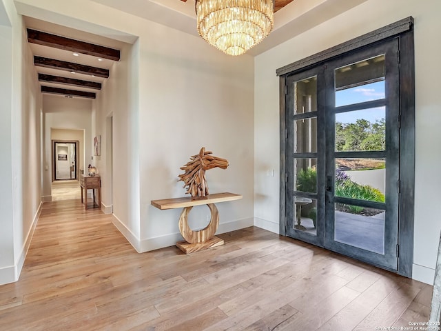 doorway to outside featuring beamed ceiling, a notable chandelier, and light wood-type flooring