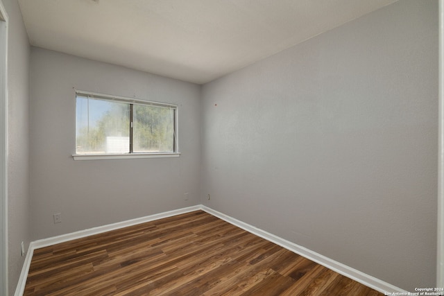 unfurnished room with dark hardwood / wood-style flooring