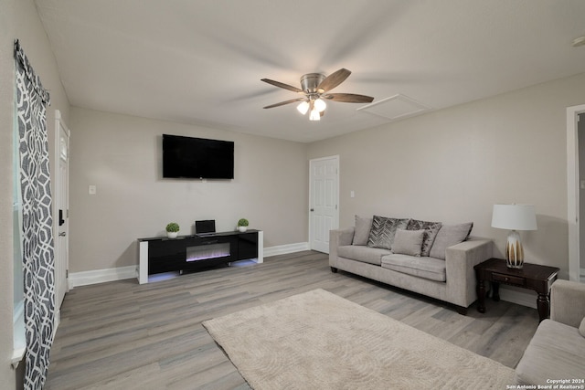 living room with light hardwood / wood-style flooring and ceiling fan