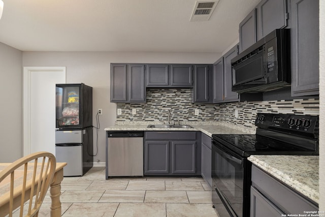 kitchen featuring gray cabinetry, black appliances, sink, and backsplash