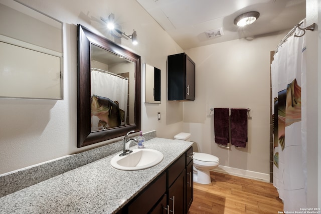 bathroom with toilet, vanity, and hardwood / wood-style flooring