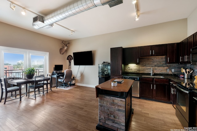 kitchen with sink, stainless steel appliances, light hardwood / wood-style flooring, backsplash, and dark brown cabinets