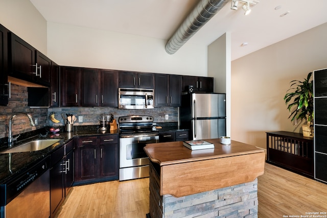 kitchen with decorative backsplash, sink, appliances with stainless steel finishes, and light hardwood / wood-style flooring