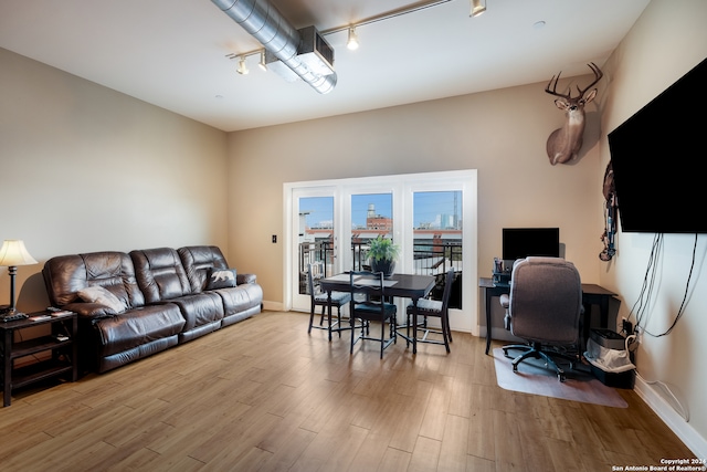 living room with light hardwood / wood-style floors and track lighting