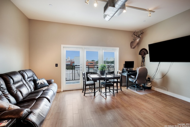 dining space featuring rail lighting and light hardwood / wood-style flooring