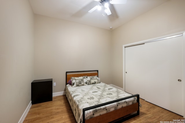 bedroom with a closet, light hardwood / wood-style floors, and ceiling fan