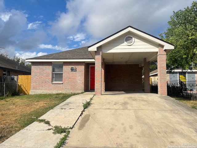 ranch-style home with a front yard and a carport