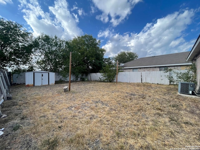 view of yard featuring central AC and a storage unit