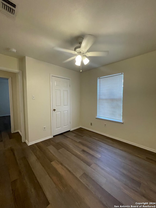 unfurnished bedroom featuring dark hardwood / wood-style floors and ceiling fan